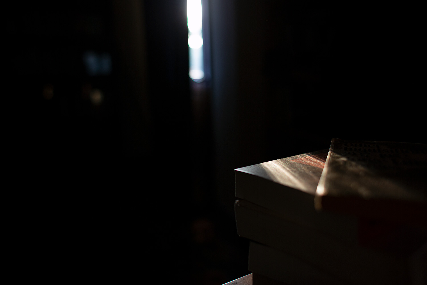 A stack of books in a ray of sunshine on a summer afternoon