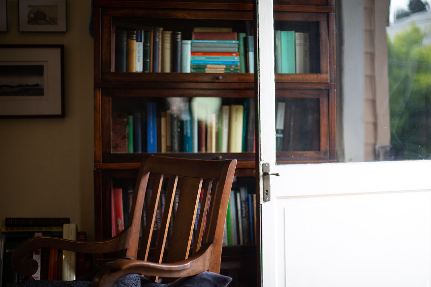 A workspace with some books and open door out onto a balcony.