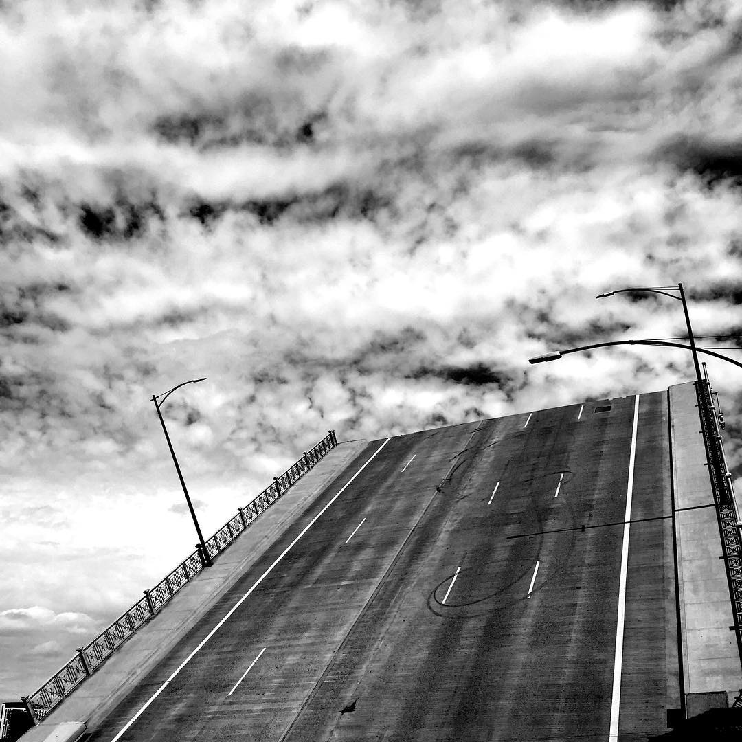 a picture of a drawbridge raised against a summer sky