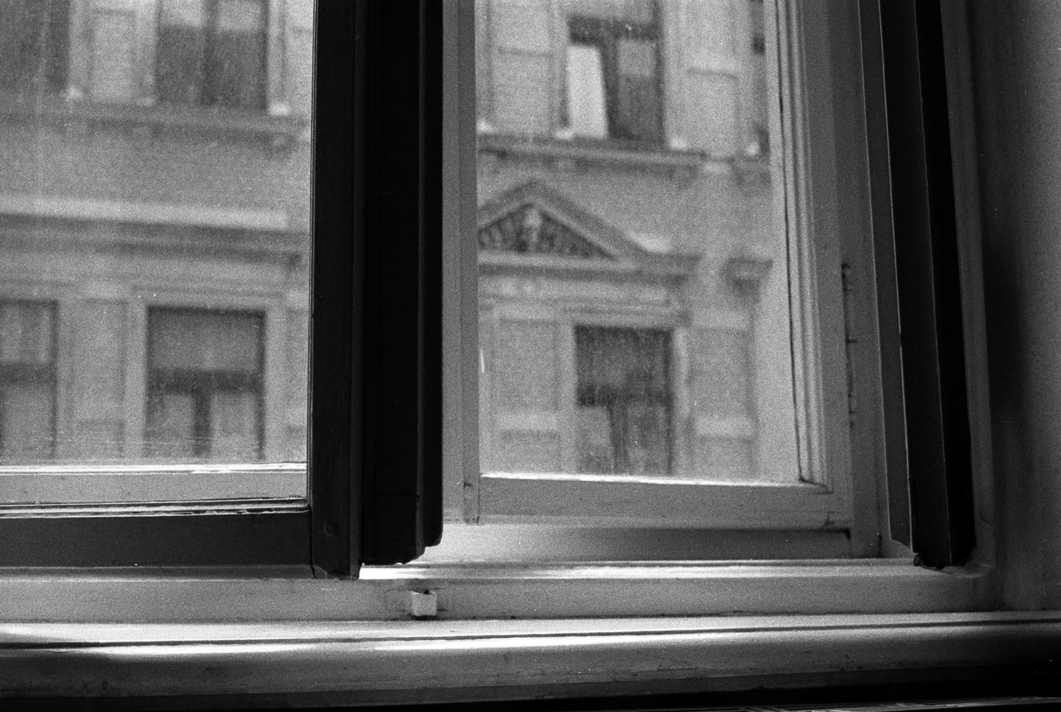 A scan of a photograph on black and white film of a slightly open window.