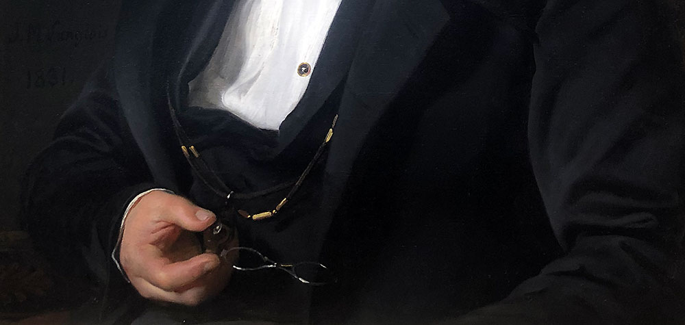 Detail of a painting, showing a hand holding a pair of silver spectacles suspended from a black cord against a background of black fabric, presumably a coat.