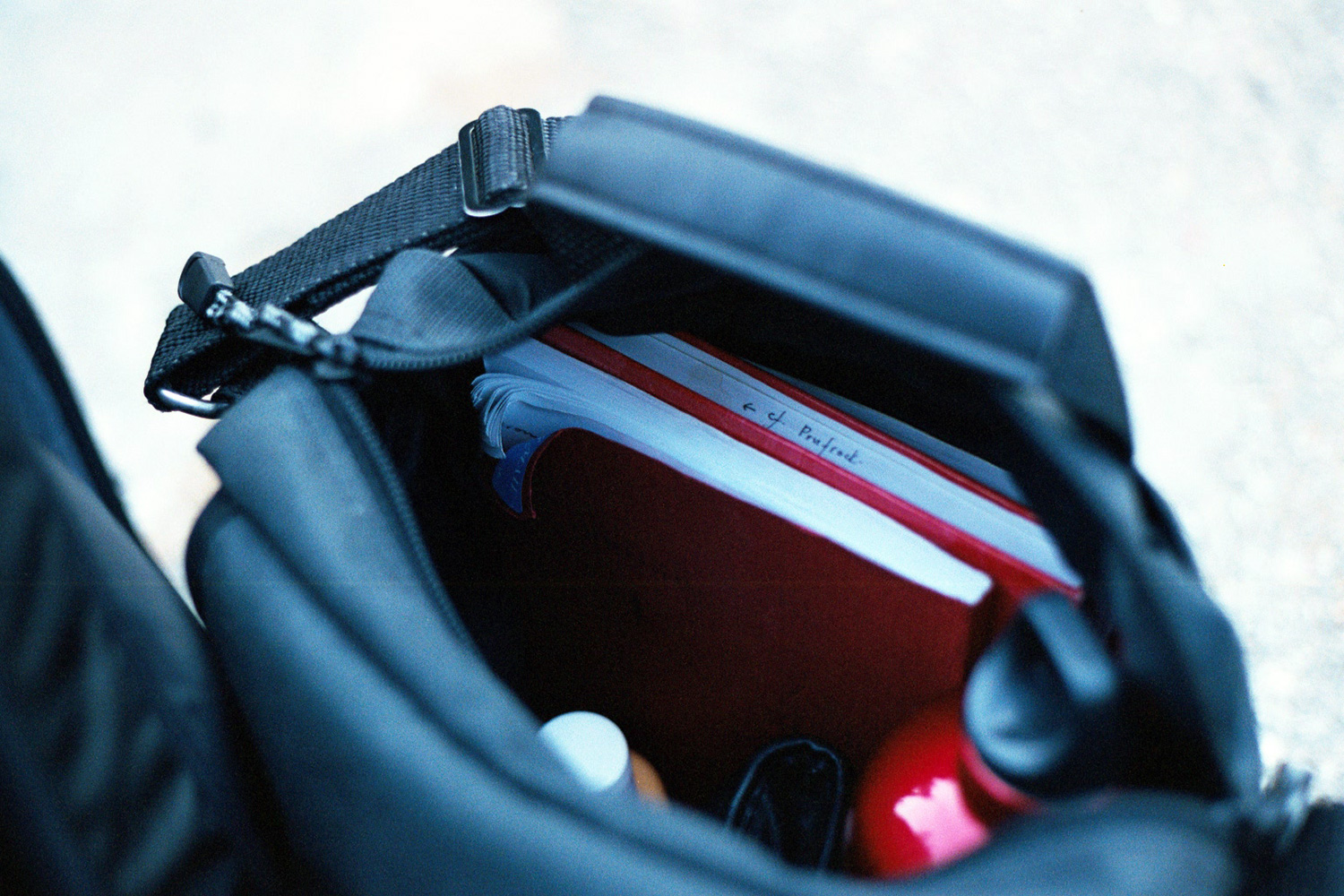 Bag with notebooks, water-bottle, and sunscreen.
